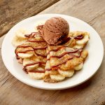 Crepes with banana and chocolat icecream on wooden table